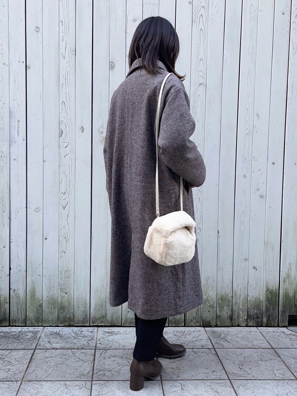 ブラウン系のその他アウター、ホワイト系のニット/セーター、ホワイト系のTシャツ/カットソーを着用したレディースの冬コーディネートの2枚目の写真