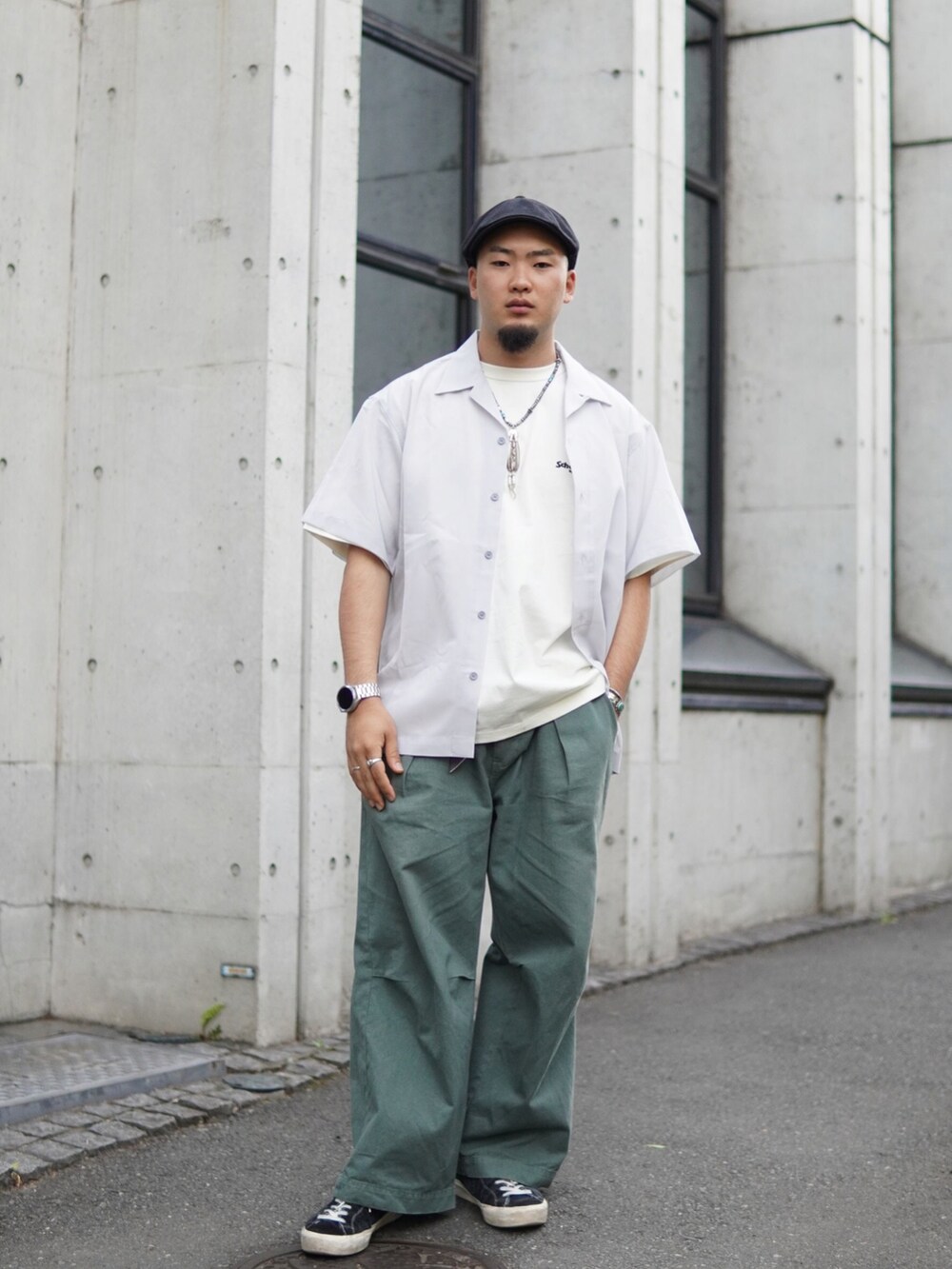 グレー系のトップス、グリーン系のチノパンツを着用したメンズの春コーディネートの2枚目の写真