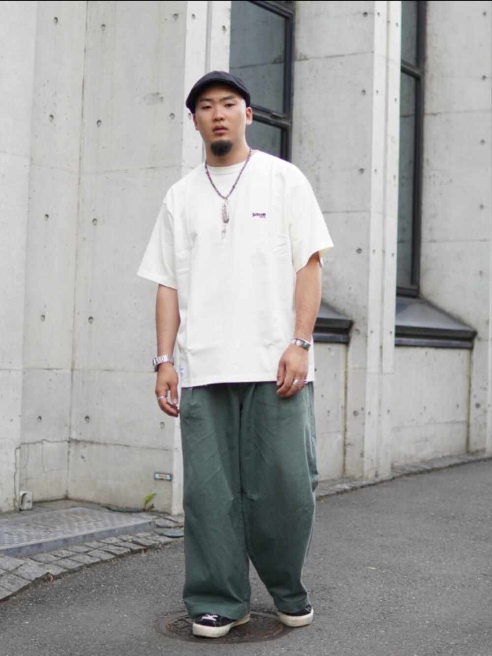 ホワイト系のTシャツ/カットソー、グリーン系のチノパンツを着用したメンズの春コーディネートの2枚目の写真