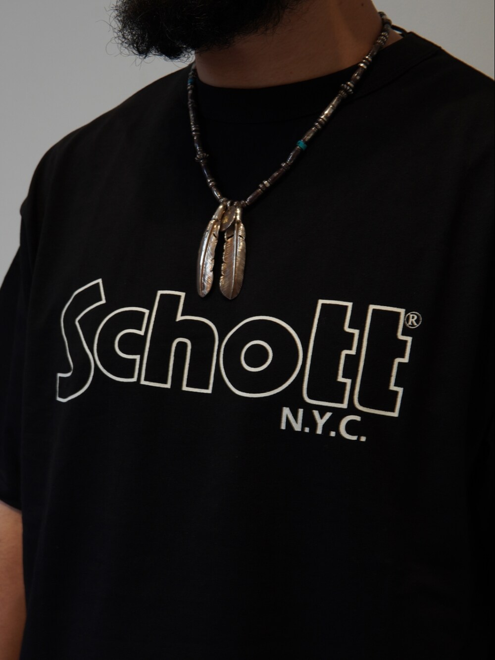 ブラック系のTシャツ/カットソー、グリーン系のチノパンツを着用したメンズの春コーディネートの2枚目の写真