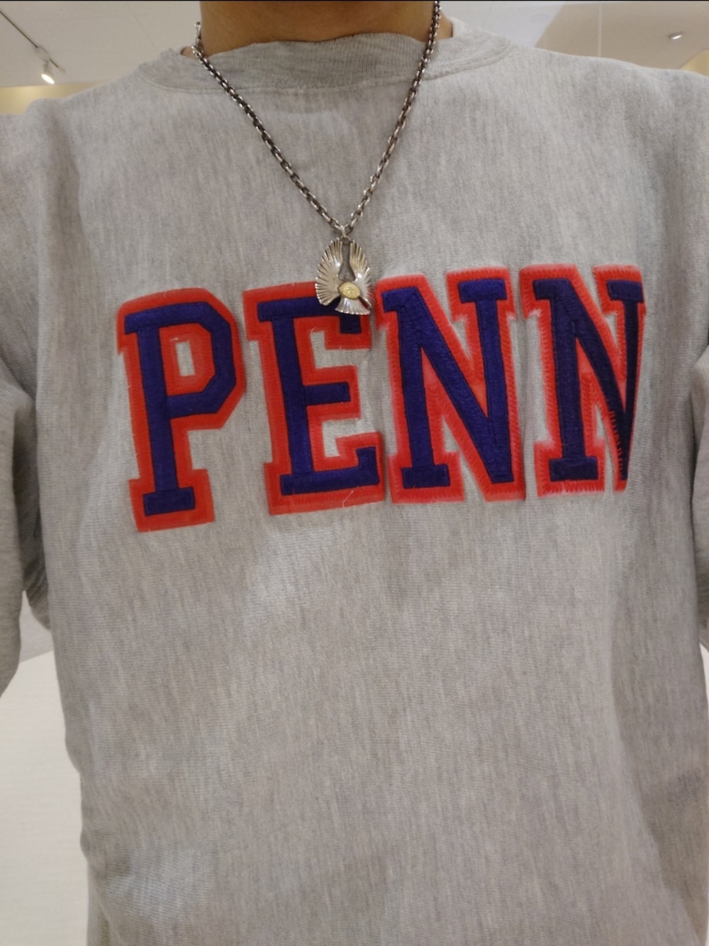 パープル系のスニーカー、ブルー系のデニムパンツ、グレー系のスウェットを着用したメンズの秋コーディネートの2枚目の写真