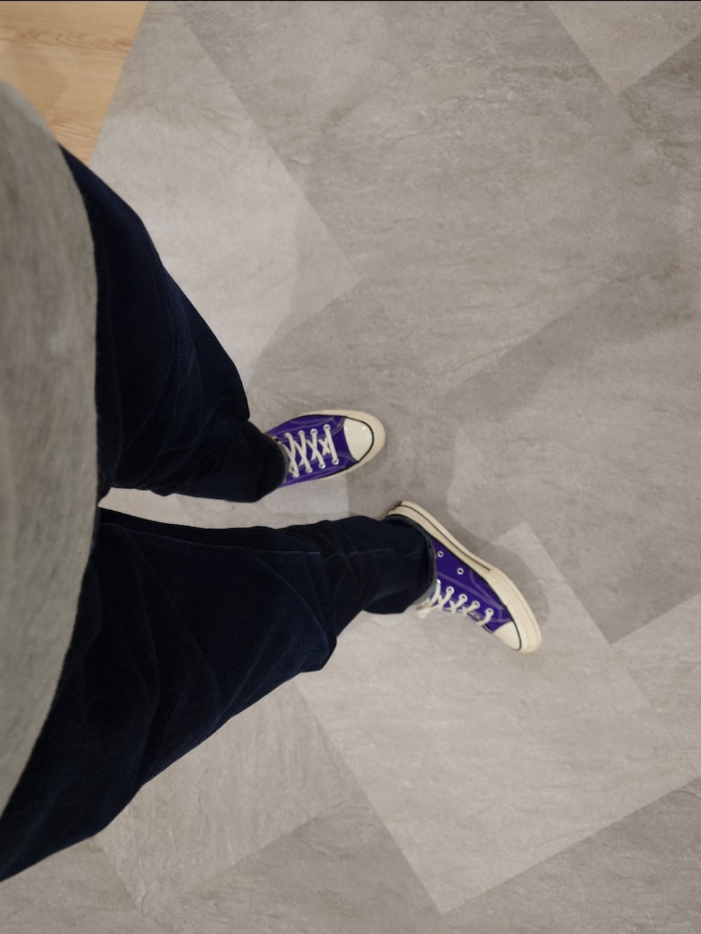 パープル系のスニーカー、ブルー系のデニムパンツ、グレー系のスウェットを着用したメンズの秋コーディネートの3枚目の写真