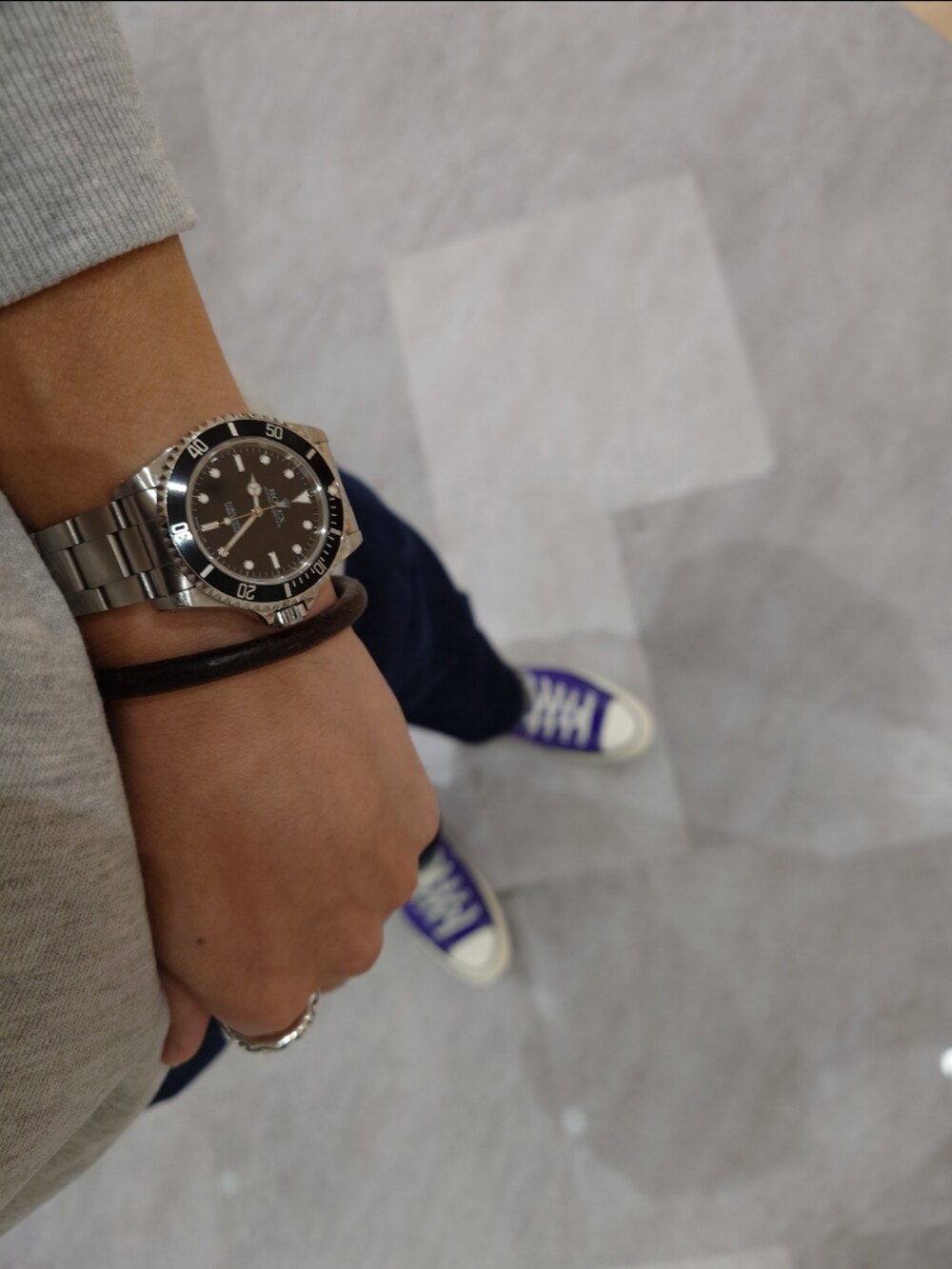 パープル系のスニーカー、ブルー系のデニムパンツ、グレー系のスウェットを着用したメンズの秋コーディネートの4枚目の写真