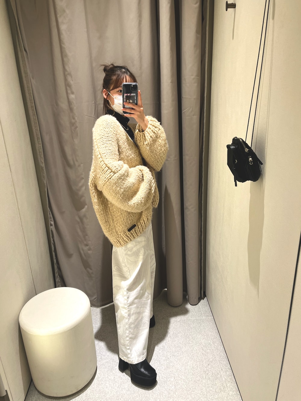 ホワイト系のデニムパンツ、ブラック系のローファー、ベージュ系のカーディガン/ボレロを着用したレディースの冬コーディネートの2枚目の写真