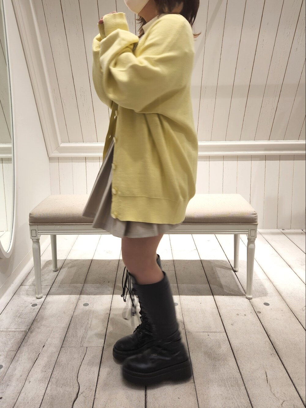 イエロー系のカーディガン/ボレロ、ベージュ系のスカート、ホワイト系のTシャツ/カットソーを着用したレディースの冬コーディネートの2枚目の写真