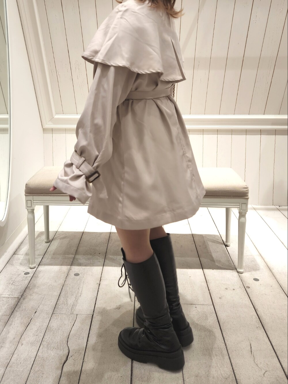 ベージュ系のトレンチコートを着用したレディースの冬コーディネートの2枚目の写真