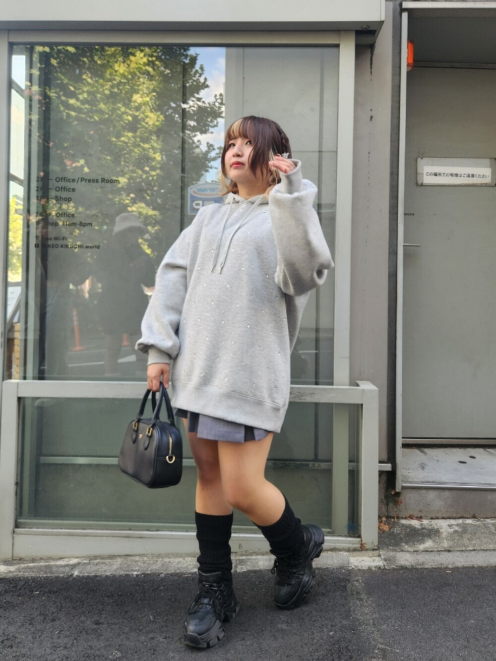 グレー系のパーカー、ブラック系のショルダーバッグを着用したレディースの秋コーディネートの2枚目の写真