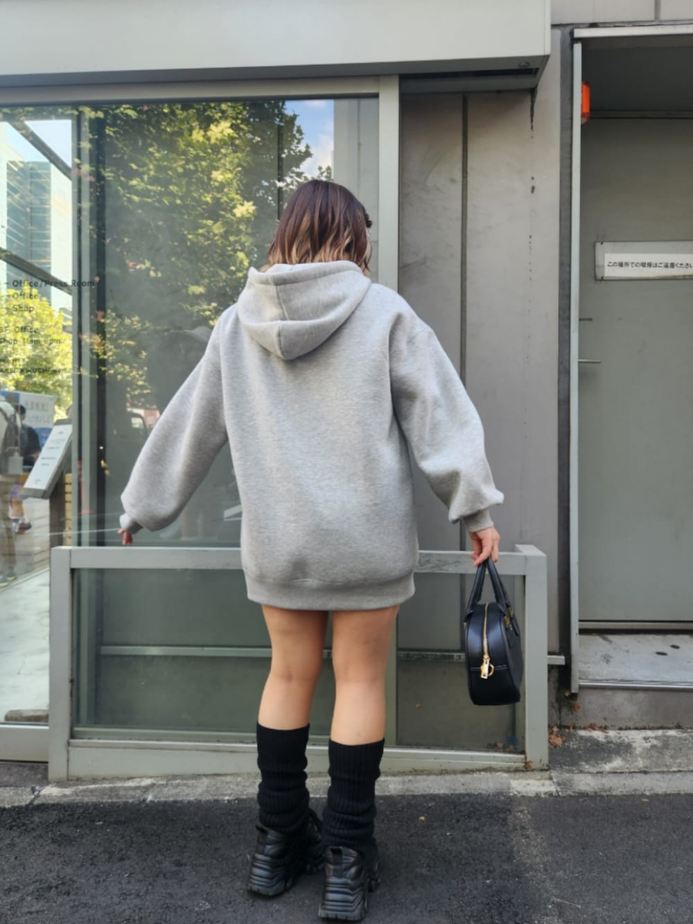 グレー系のパーカー、ブラック系のショルダーバッグを着用したレディースの秋コーディネートの3枚目の写真