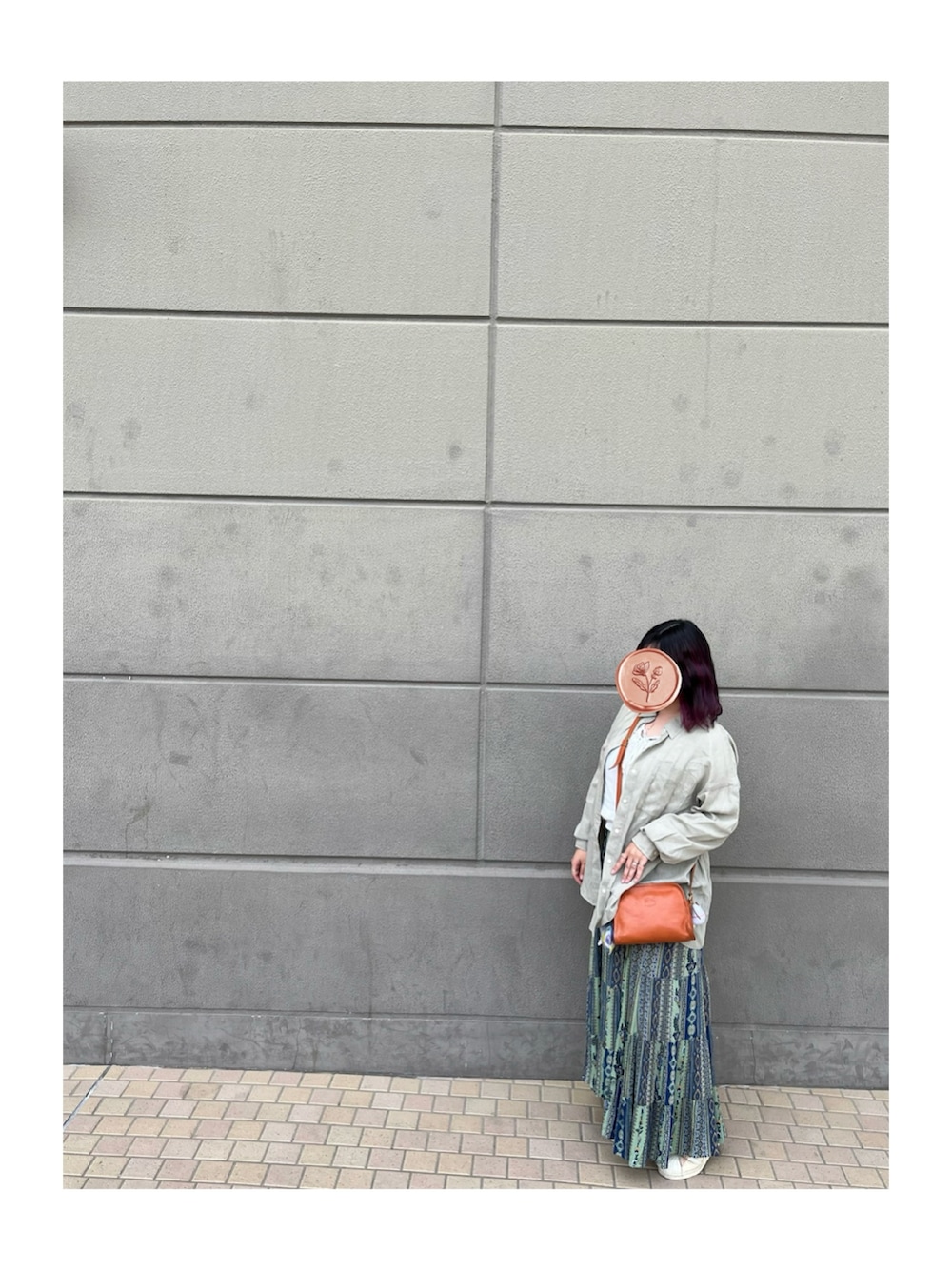 グリーン系のワンピース、ホワイト系のスニーカー、オレンジ系のショルダーバッグを着用したレディースの春コーディネートの2枚目の写真