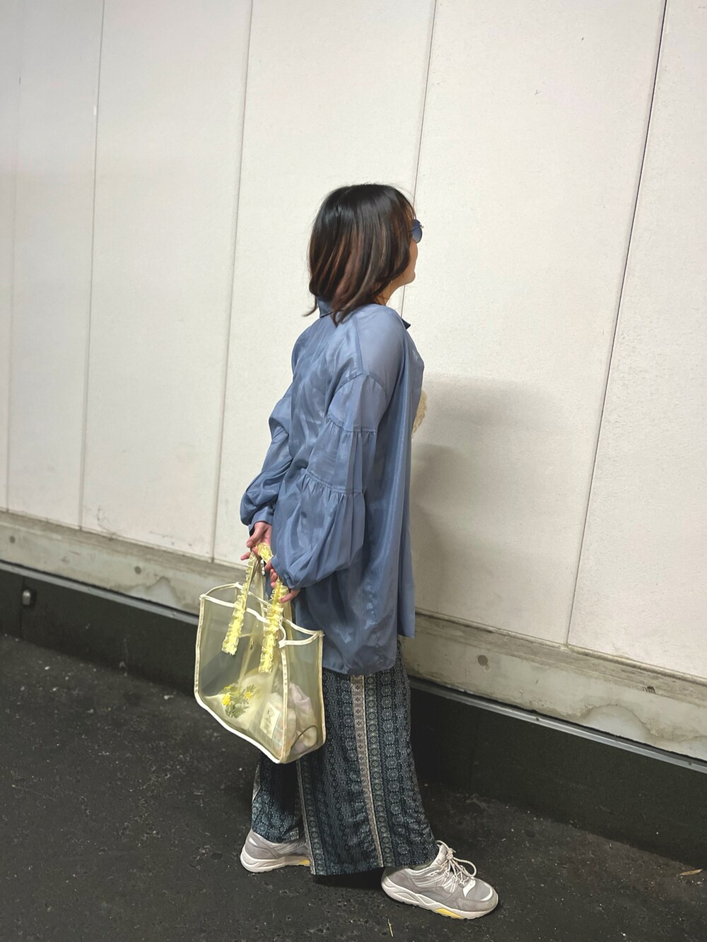 ホワイト系のトップス、グレー系のスニーカーを着用したレディースの春コーディネートの2枚目の写真