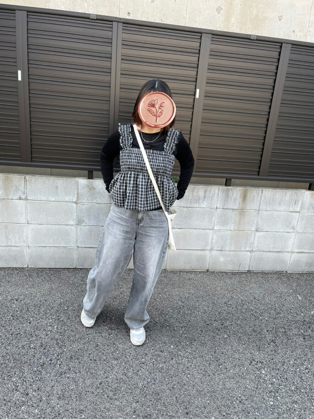 ブラック系のトップス、ブラック系のトップス、グレー系のデニムパンツを着用したレディースの春コーディネートの3枚目の写真