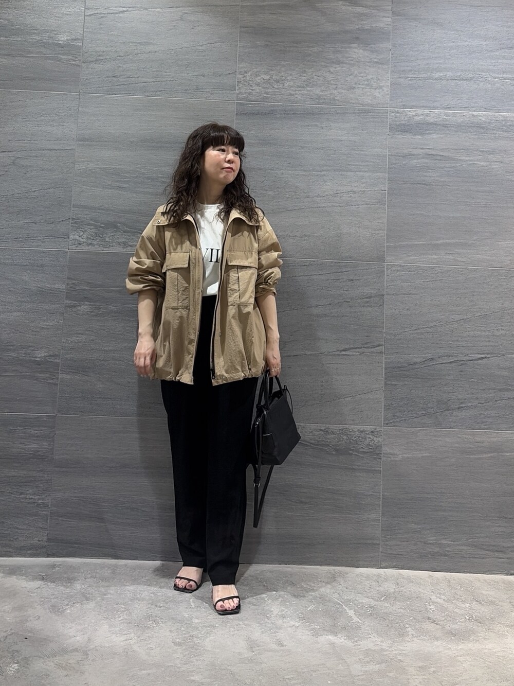 ベージュ系のブルゾン、ブラック系のトートバッグ、ブラック系のその他パンツを着用したレディースの春コーディネートの2枚目の写真