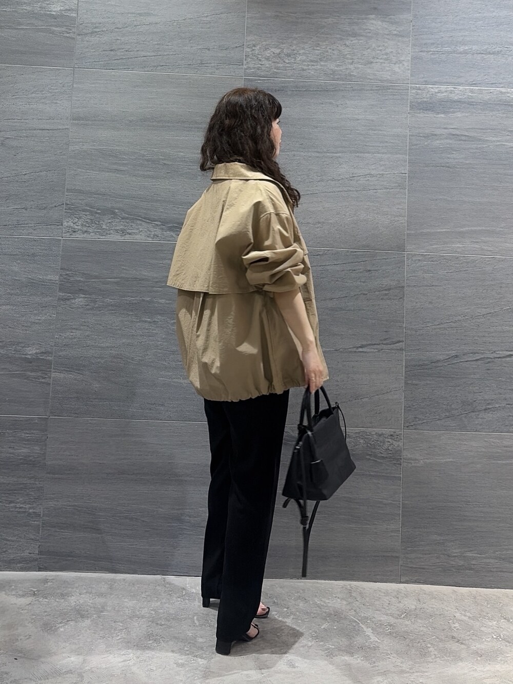 ベージュ系のブルゾン、ブラック系のトートバッグ、ブラック系のその他パンツを着用したレディースの春コーディネートの3枚目の写真