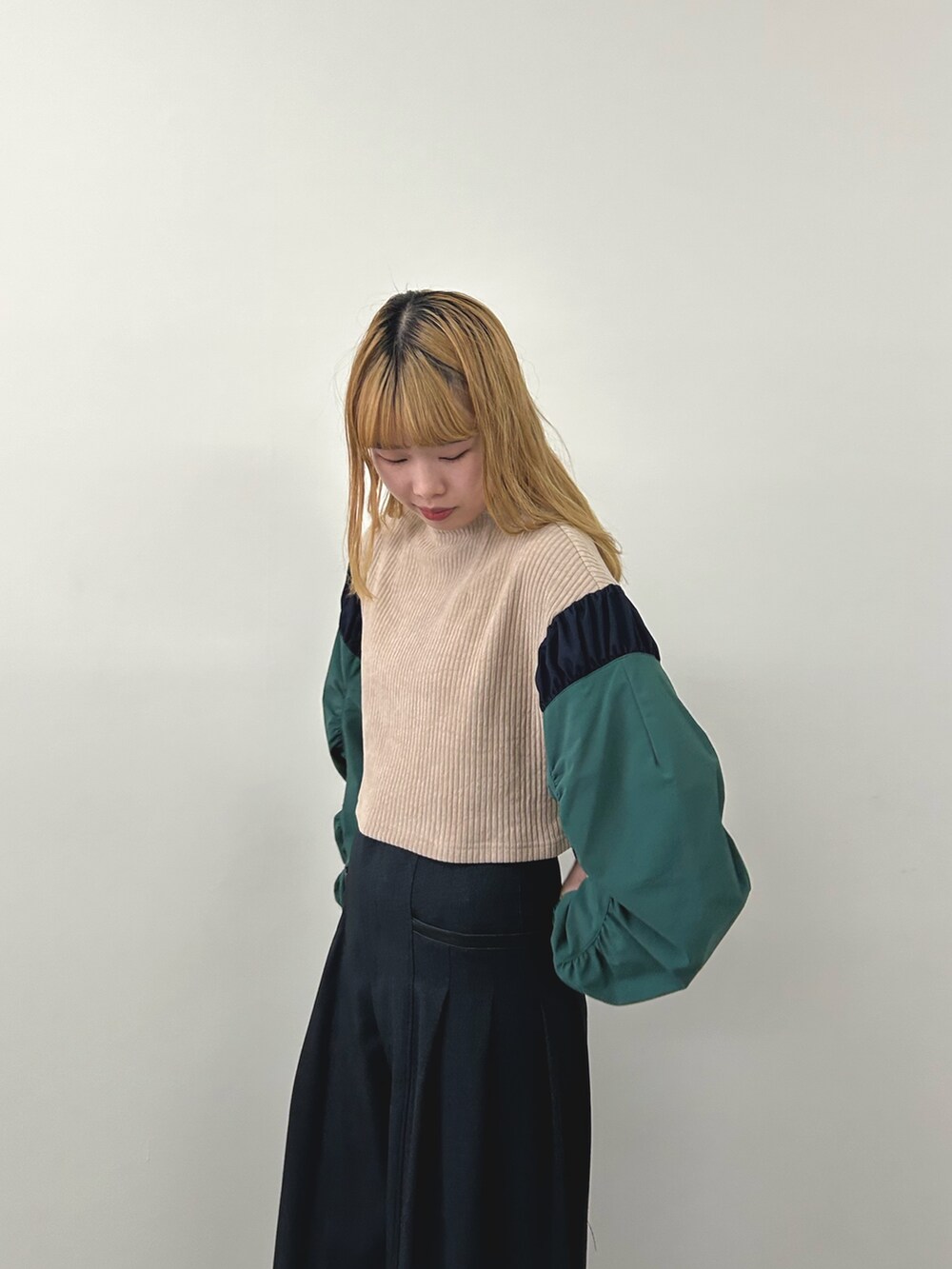 ベージュ系のニット/セーター、グレー系のスラックスを着用したレディースの秋コーディネートの2枚目の写真