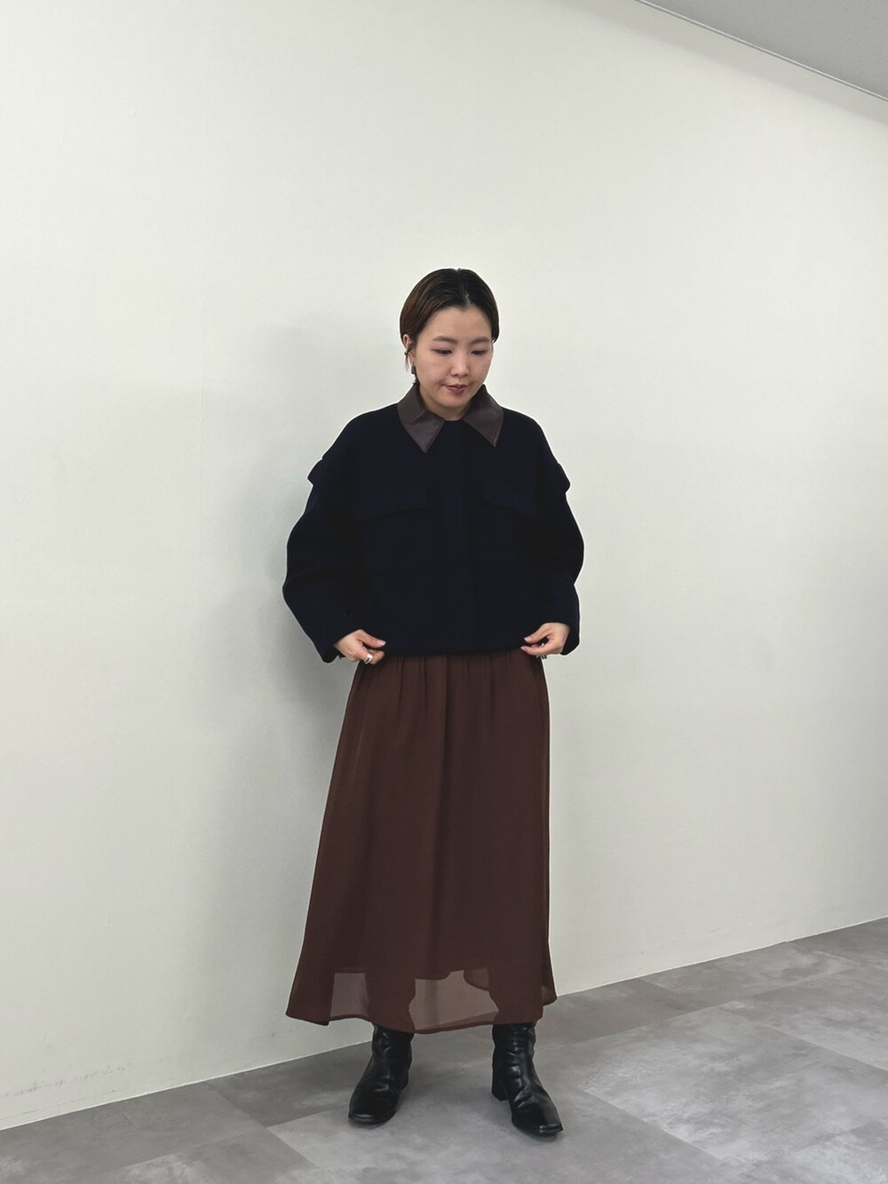 ブルー系のミリタリージャケット、ブラウン系のワンピースを着用したレディースの秋コーディネートの2枚目の写真