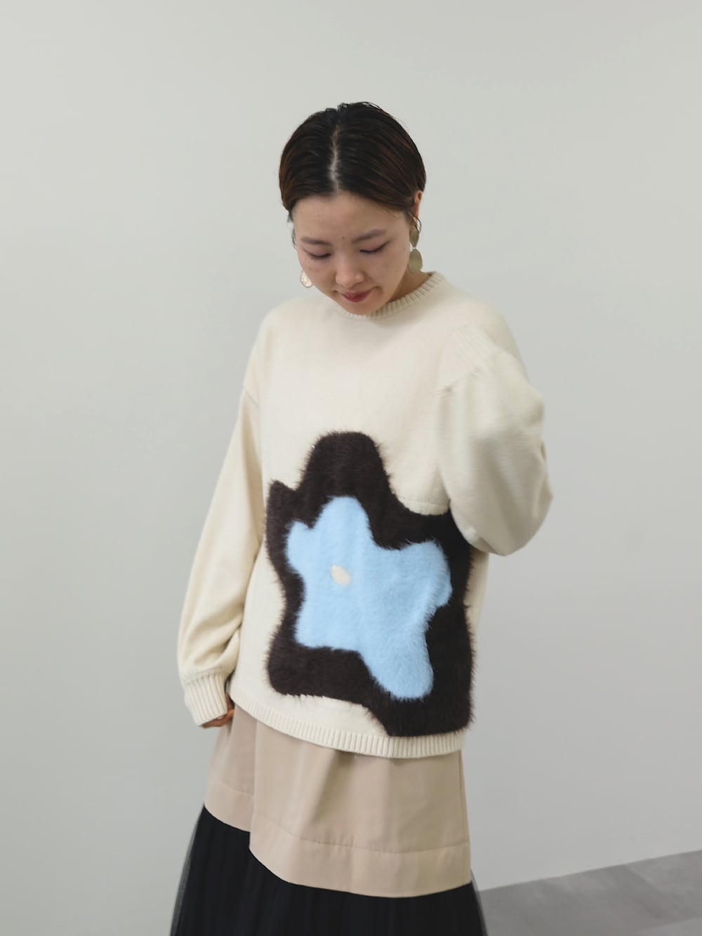 ホワイト系のニット/セーター、ベージュ系のスカートを着用したレディースの冬コーディネートの2枚目の写真