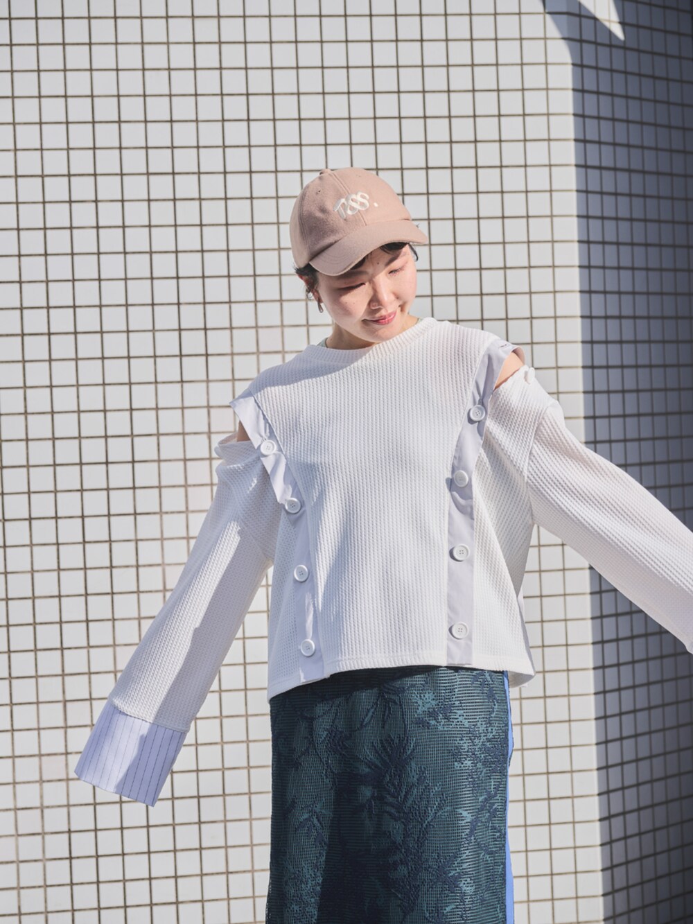 グリーン系のスカートを着用したレディースの春コーディネートの3枚目の写真