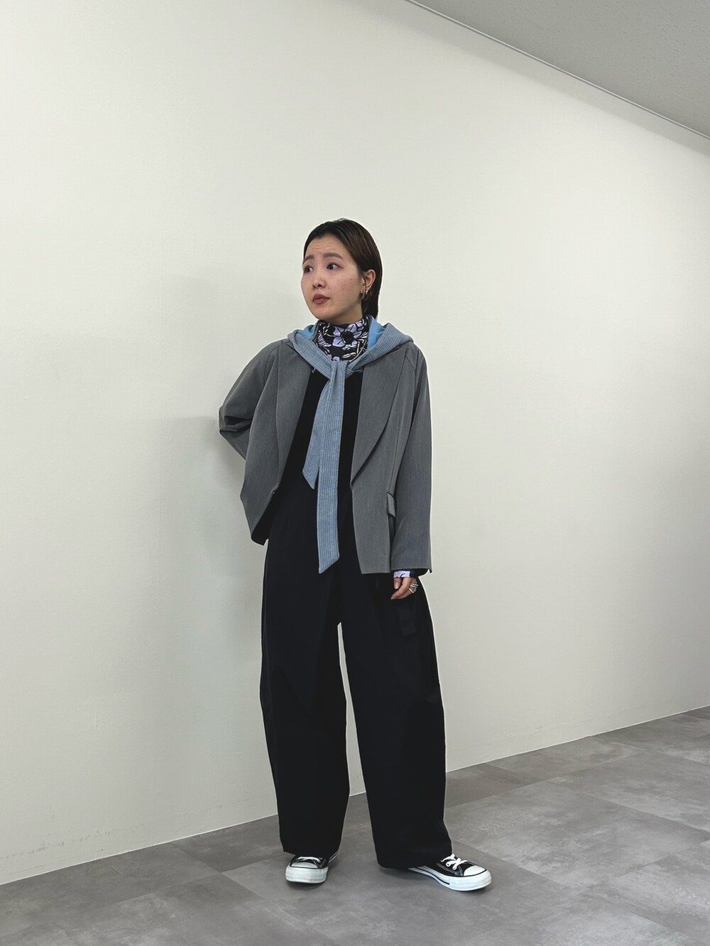 グレー系のテーラードジャケット、ブラック系のチノパンツを着用したレディースの秋コーディネートの2枚目の写真