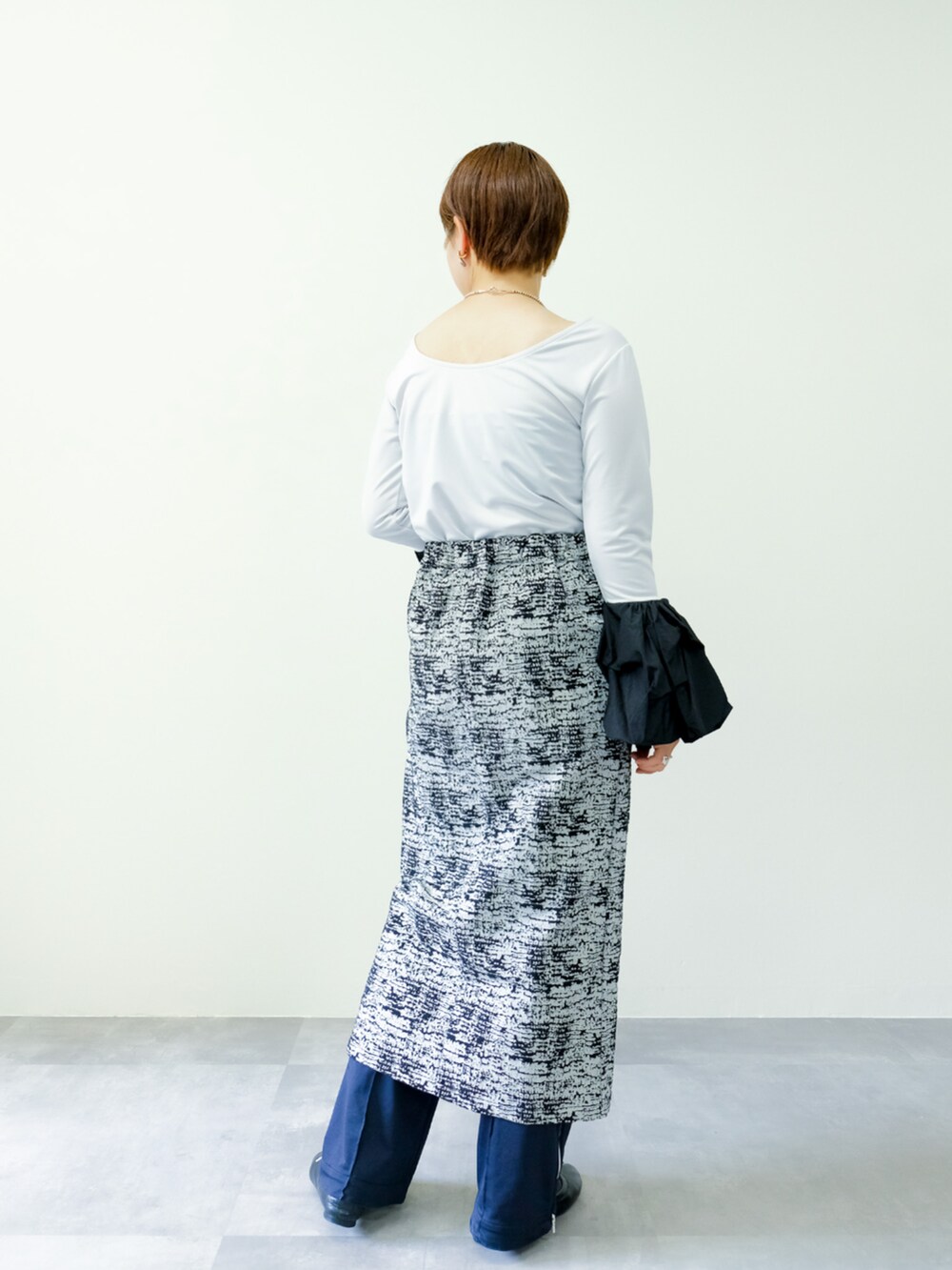 グレー系のTシャツ/カットソー、ブラック系のスカートを着用したレディースの秋コーディネートの2枚目の写真