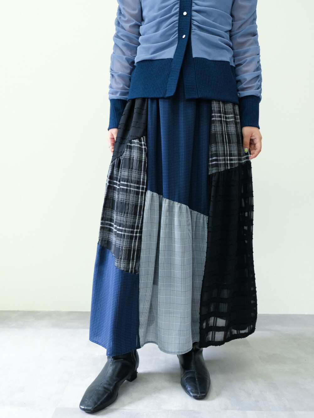 グレー系のカーディガン/ボレロ、ブラック系のスカートを着用したレディースの秋コーディネートの5枚目の写真