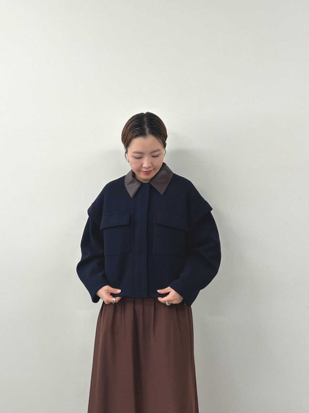 ブルー系のミリタリージャケット、ブラウン系のワンピースを着用したレディースの秋コーディネートの4枚目の写真