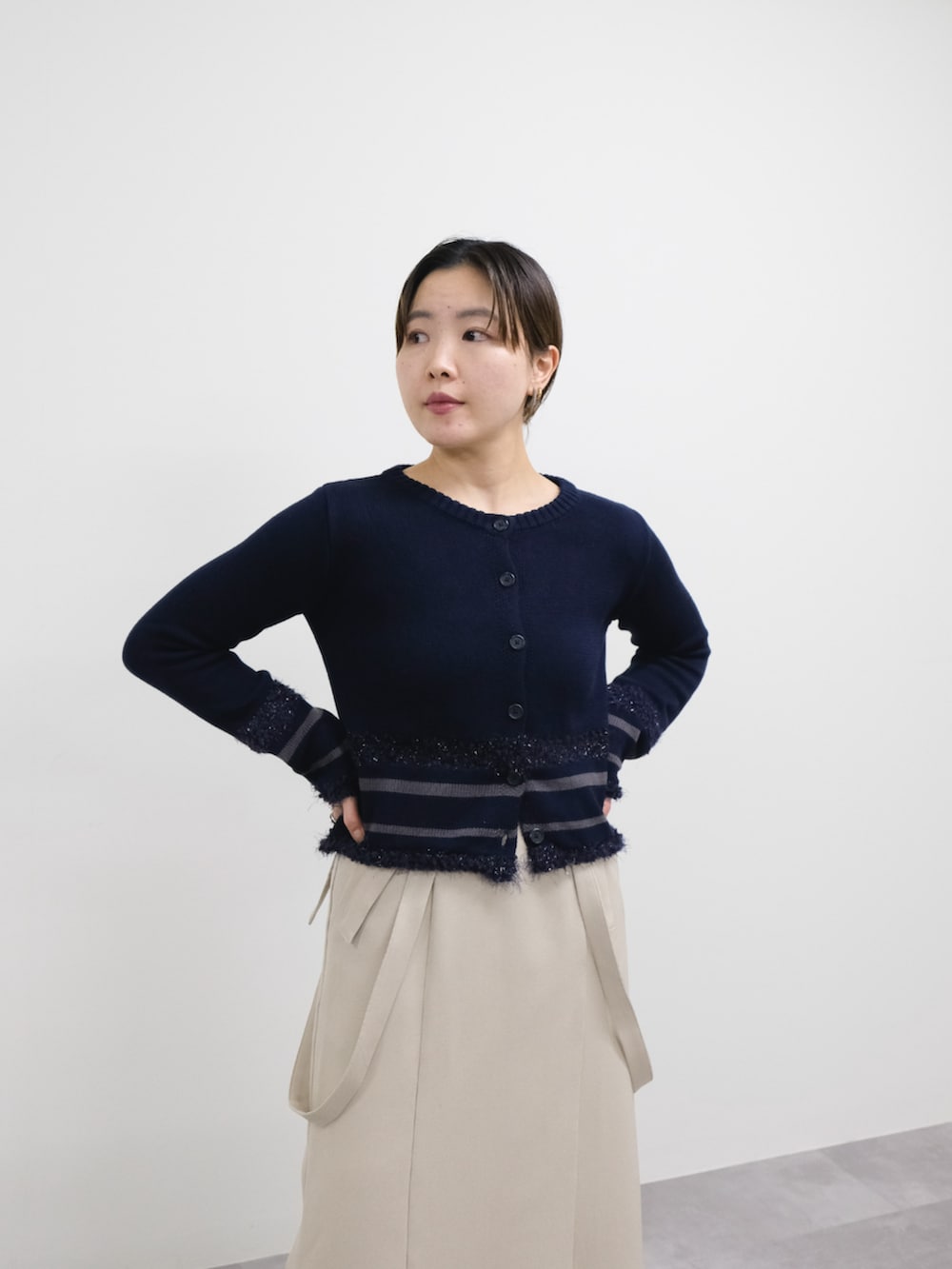 ブルー系のカーディガン/ボレロ、ベージュ系のスカートを着用したレディースの冬コーディネートの2枚目の写真