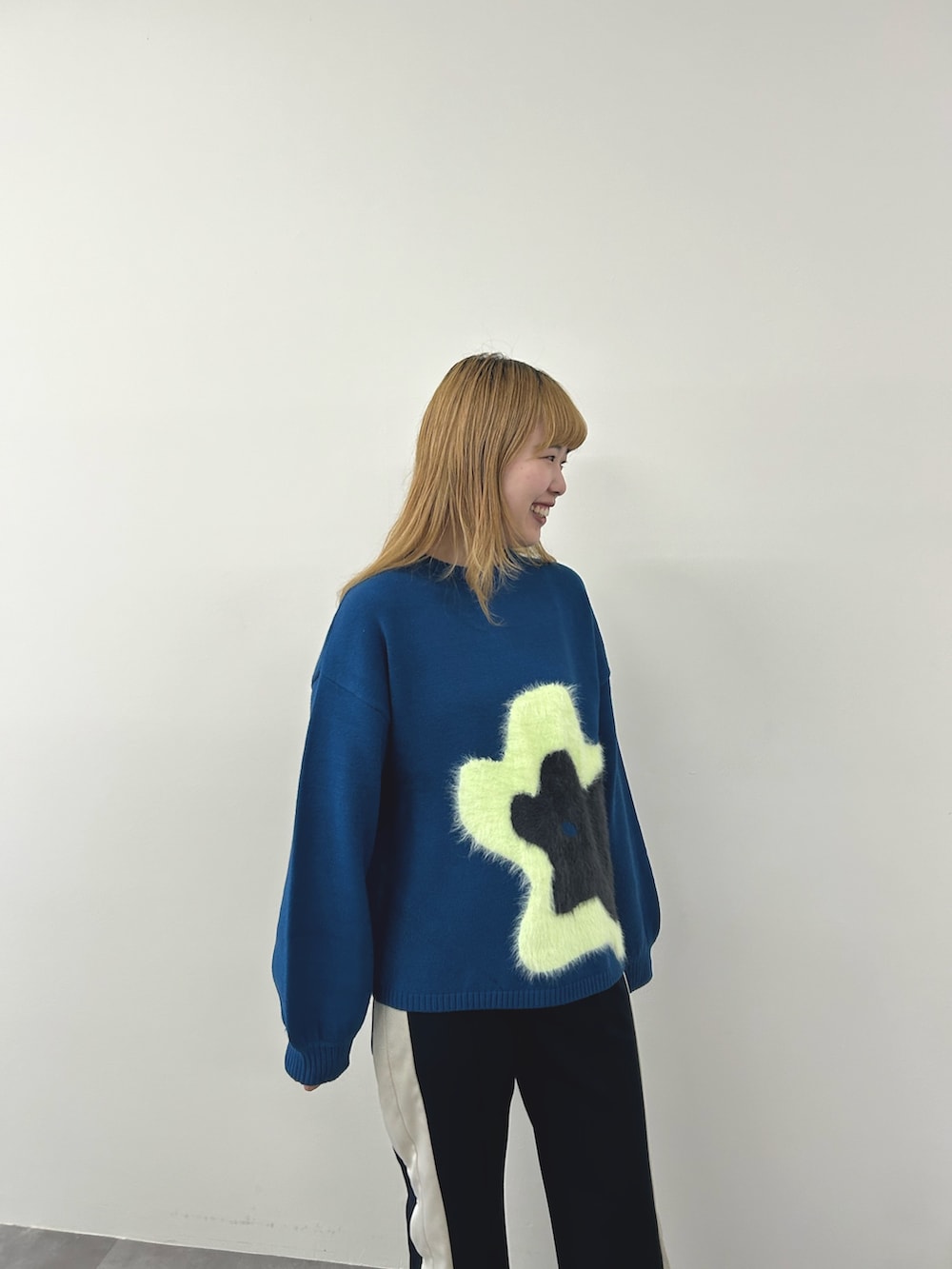 グリーン系のニット/セーター、ブルー系のその他パンツを着用したレディースの秋コーディネートの2枚目の写真