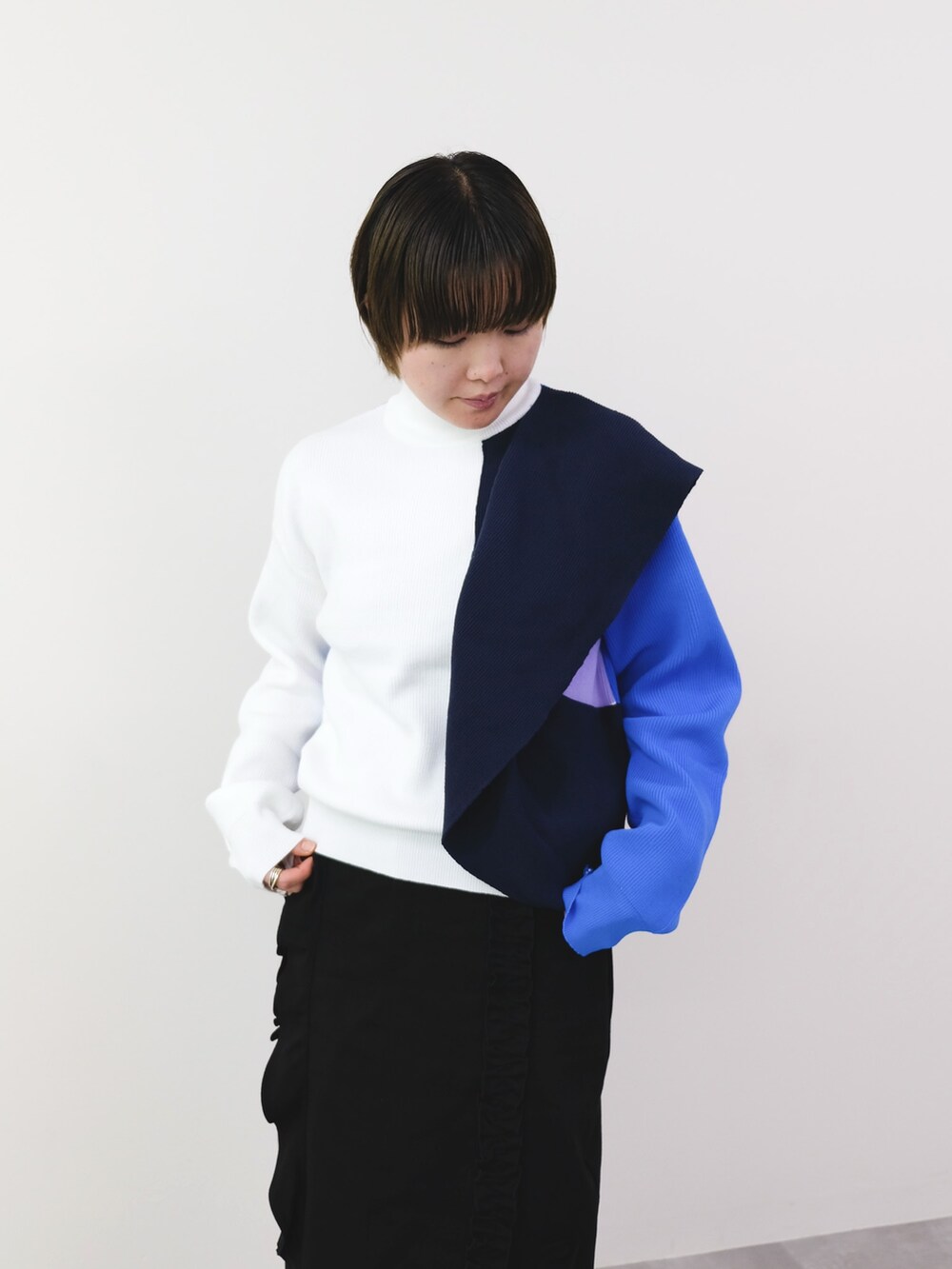 ホワイト系のニット/セーター、ブラック系のスカートを着用したレディースの冬コーディネートの2枚目の写真