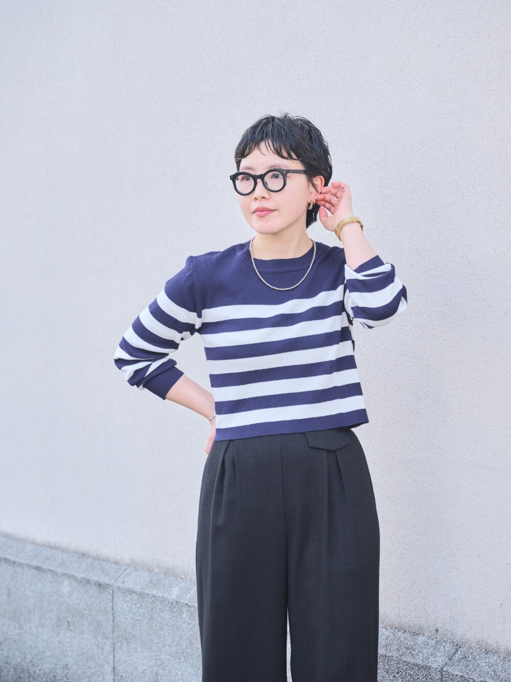 ブラック系のスラックスを着用したレディースの春コーディネートの3枚目の写真