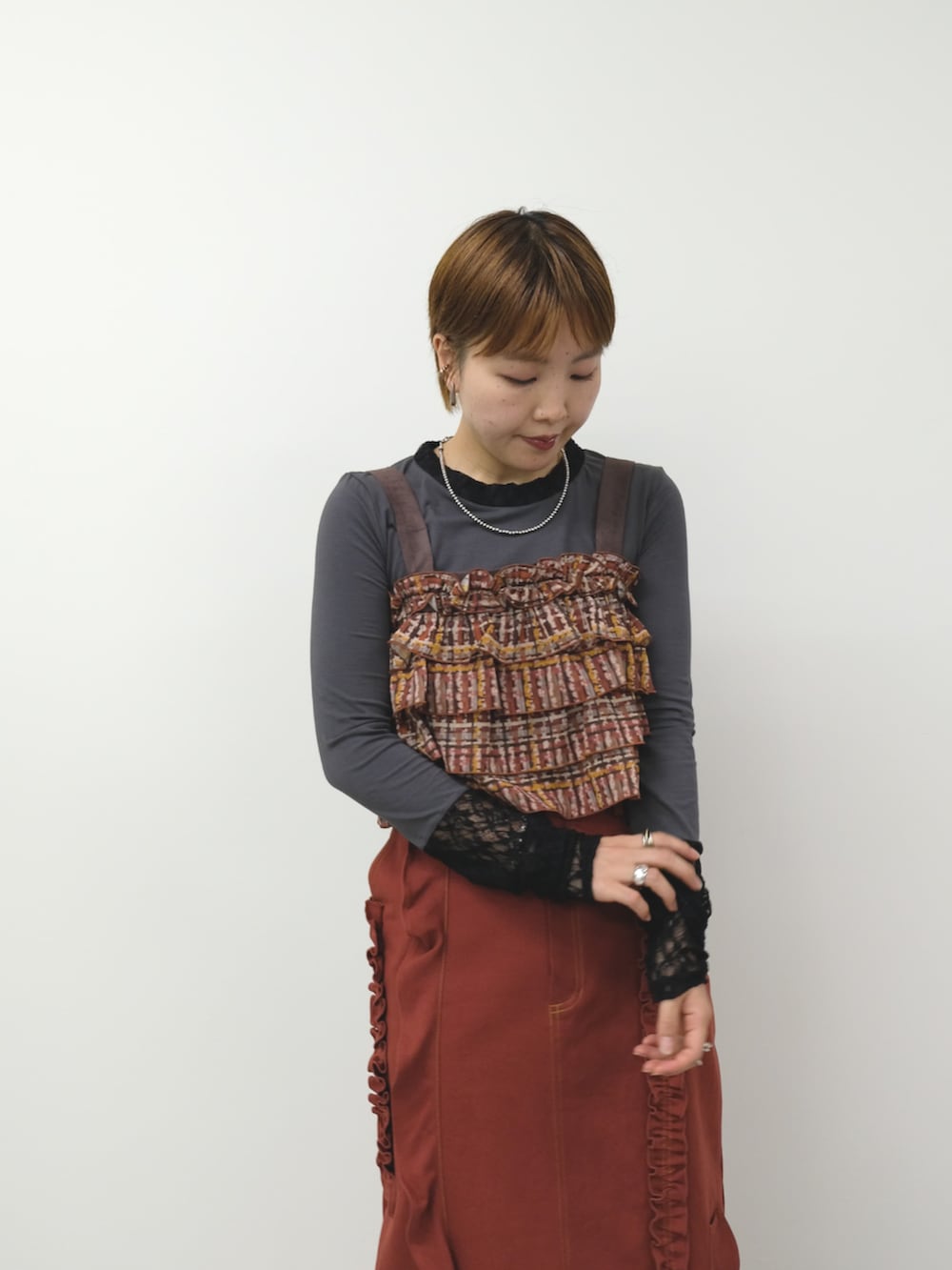 グレー系のTシャツ/カットソー、ブラウン系のその他トップス、レッド系のスカートを着用したレディースの秋コーディネートの2枚目の写真