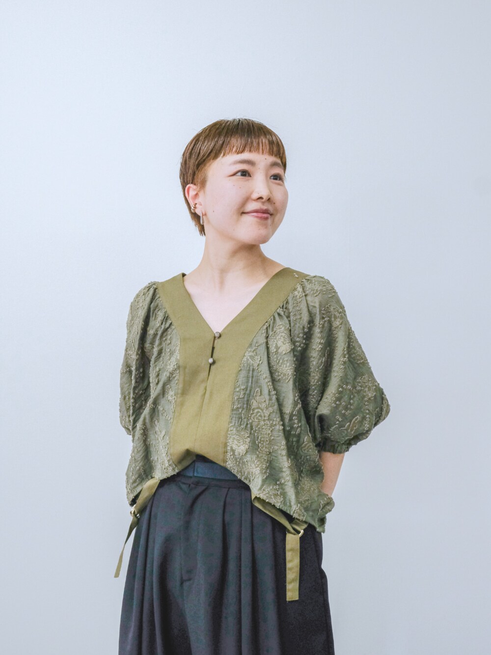 グリーン系のシャツ/ブラウスを着用したレディースの夏コーディネートの2枚目の写真