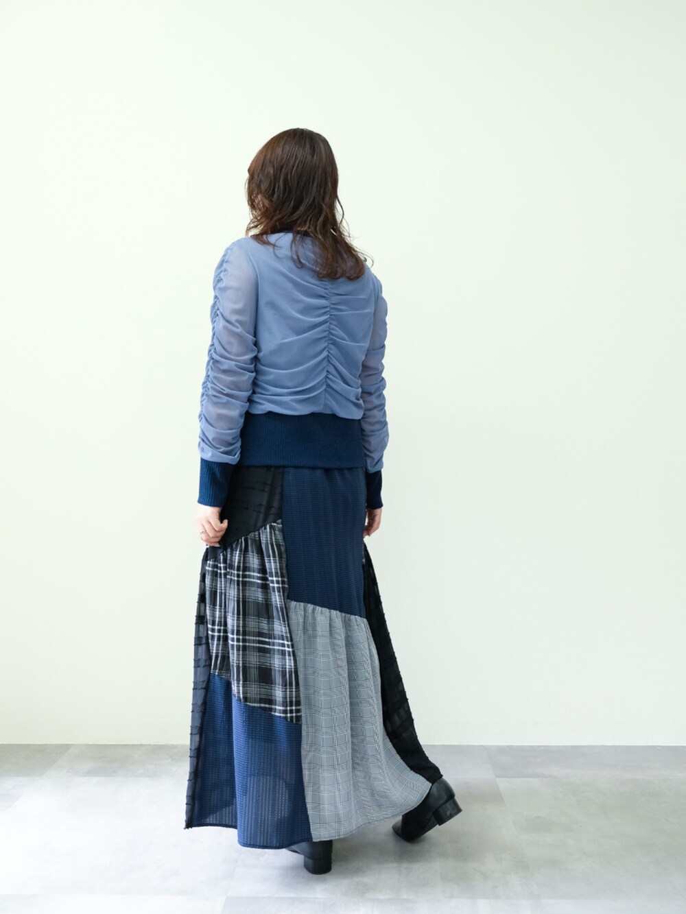 グレー系のカーディガン/ボレロ、ブラック系のスカートを着用したレディースの秋コーディネートの2枚目の写真