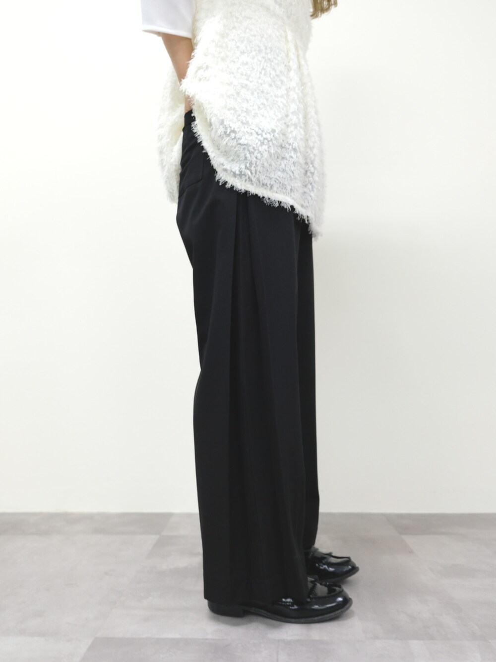 ホワイト系のTシャツ/カットソー、ブラック系のスラックスを着用したレディースの秋コーディネートの3枚目の写真