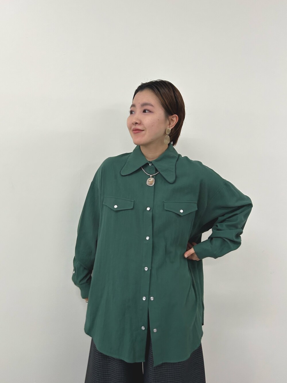 グリーン系のシャツ/ブラウス、グレー系のスラックスを着用したレディースの秋コーディネートの4枚目の写真