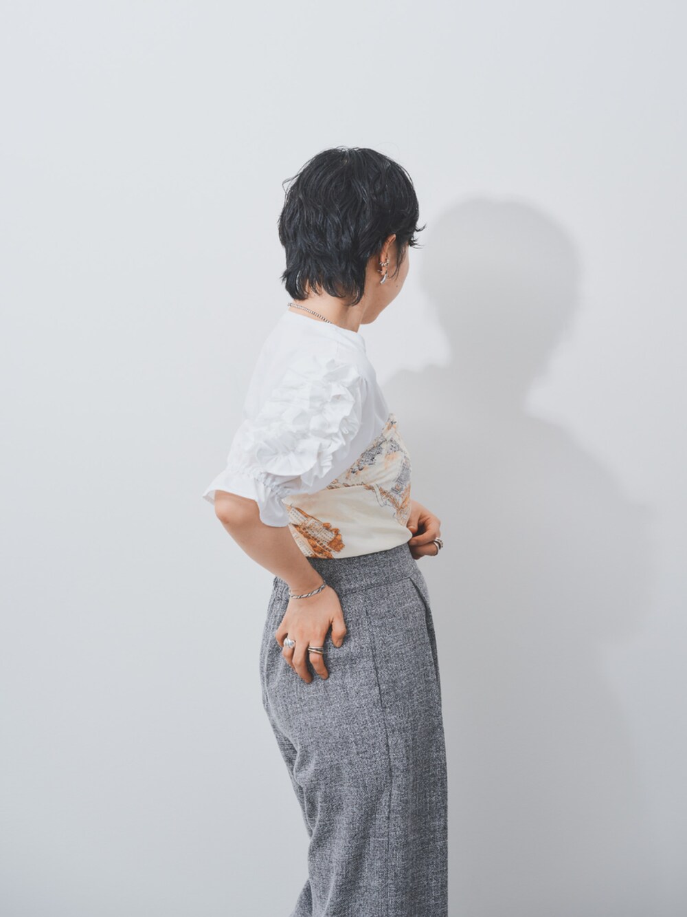 ホワイト系のTシャツ/カットソー、グレー系のスラックスを着用したレディースの夏コーディネートの3枚目の写真