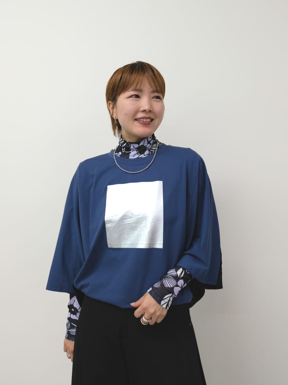 ブラック系のスラックス、ブルー系のTシャツ/カットソーを着用したレディースの秋コーディネートの2枚目の写真