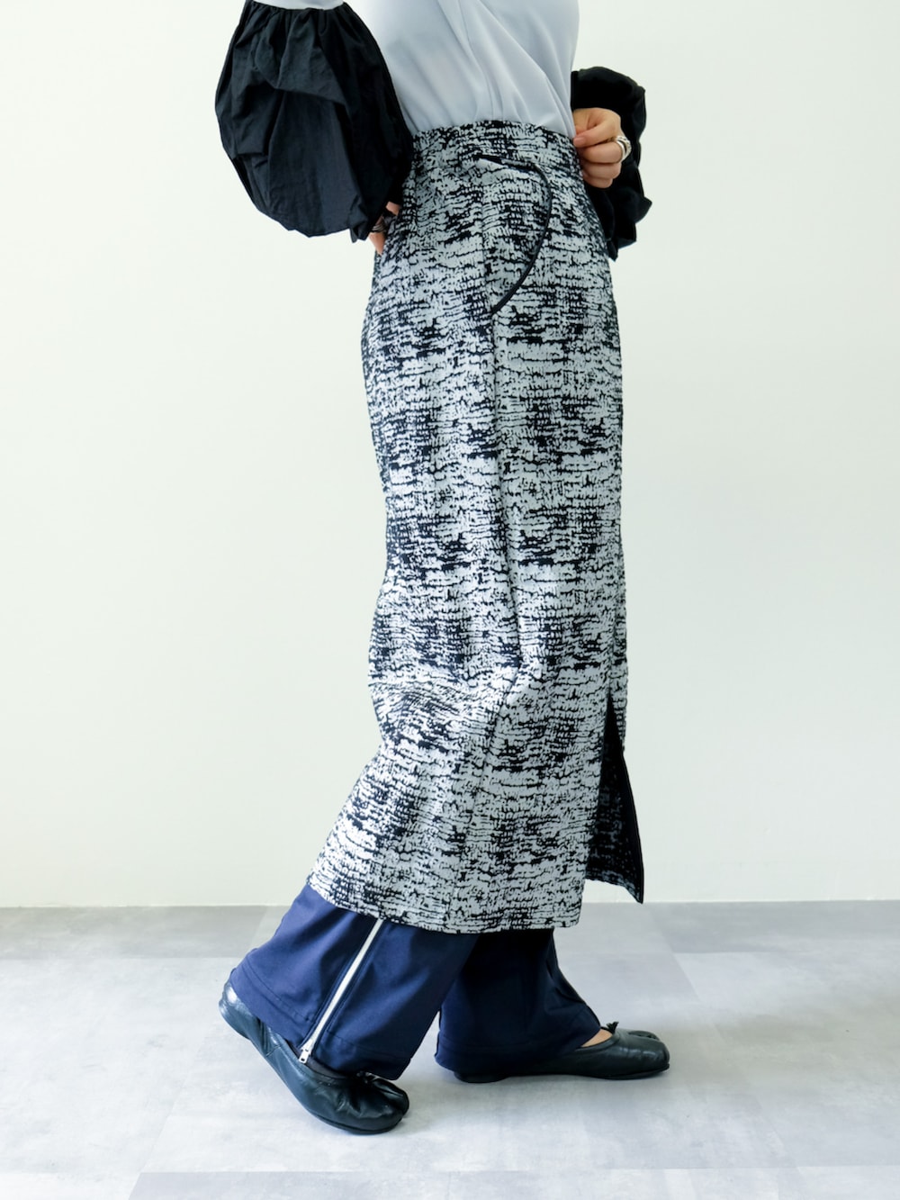 グレー系のTシャツ/カットソー、ブラック系のスカートを着用したレディースの秋コーディネートの3枚目の写真