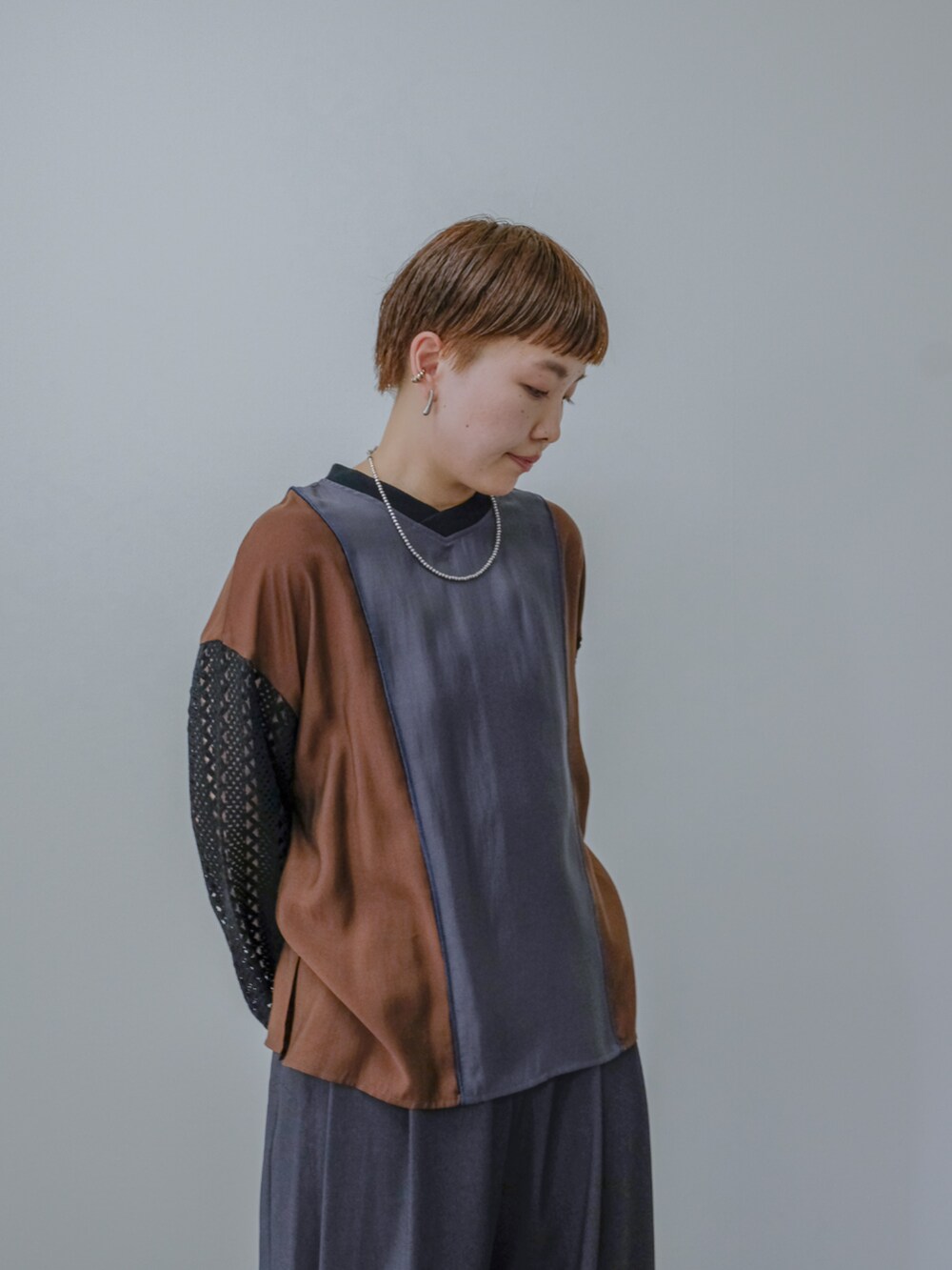 グレー系のシャツ/ブラウス、グレー系のスラックスを着用したレディースの秋コーディネートの3枚目の写真