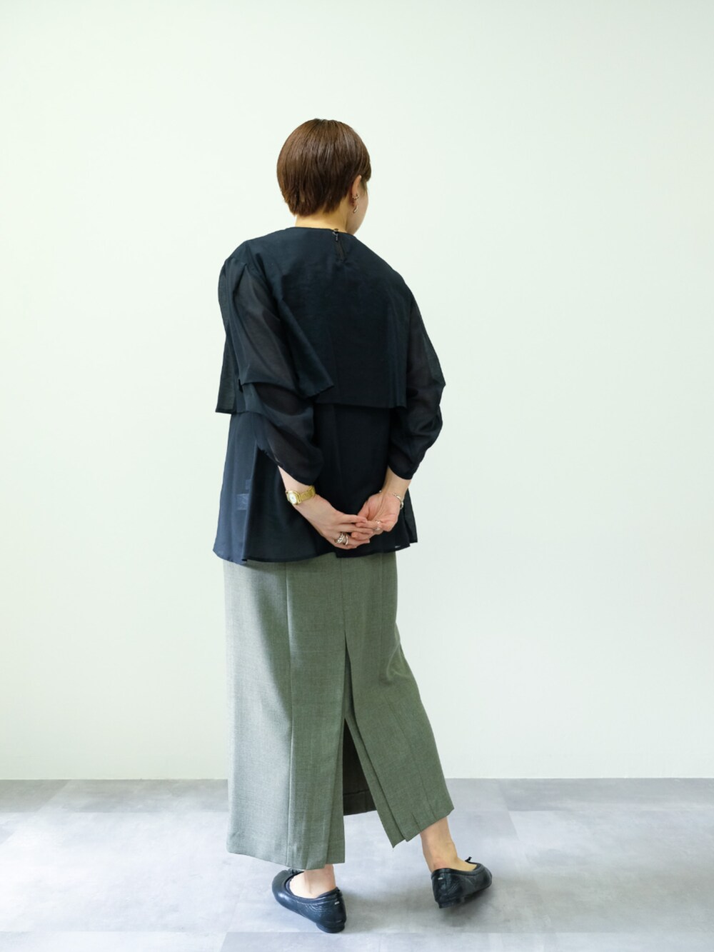 ブラック系のシャツ/ブラウス、グリーン系のワンピースを着用したレディースの秋コーディネートの2枚目の写真