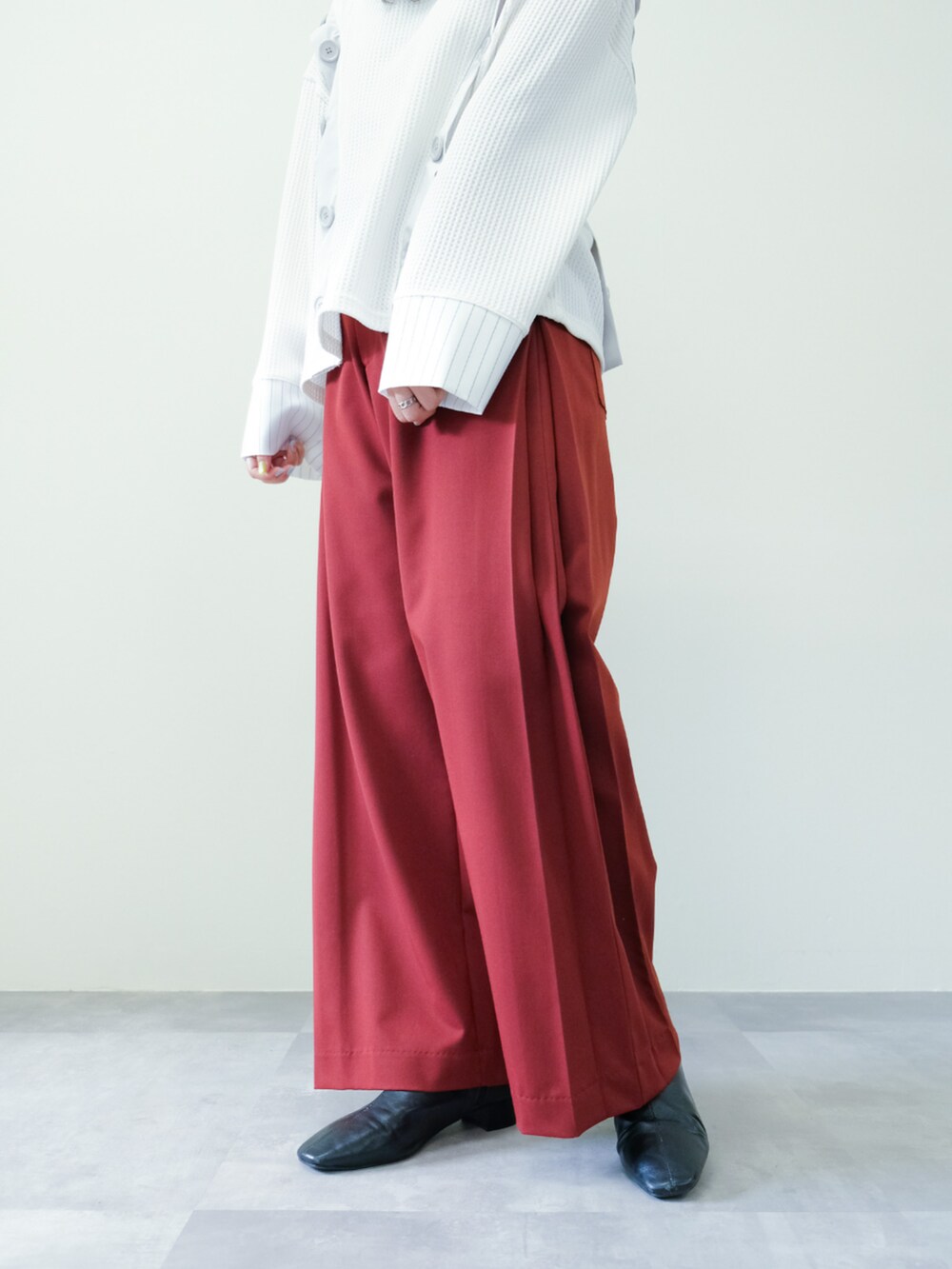 ホワイト系のTシャツ/カットソー、レッド系のスラックスを着用したレディースの秋コーディネートの3枚目の写真