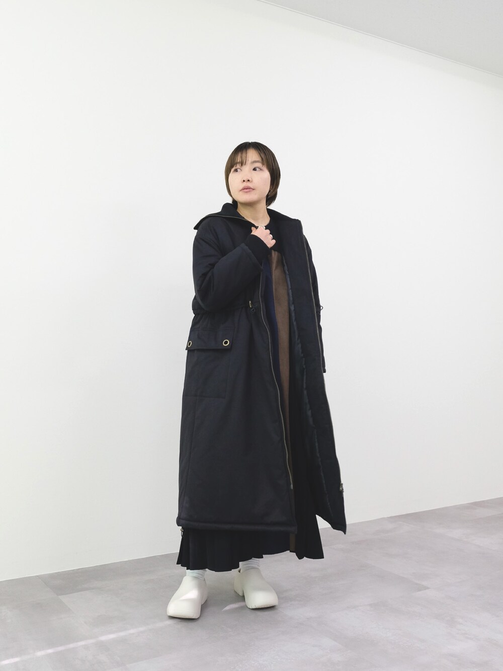 ブラック系のモッズコート、グレー系のワンピースを着用したレディースの冬コーディネートの2枚目の写真