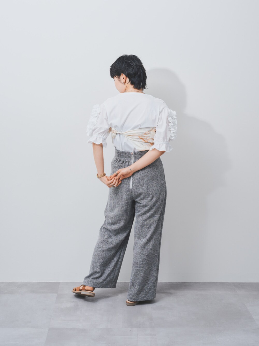 ホワイト系のTシャツ/カットソー、グレー系のスラックスを着用したレディースの夏コーディネートの4枚目の写真