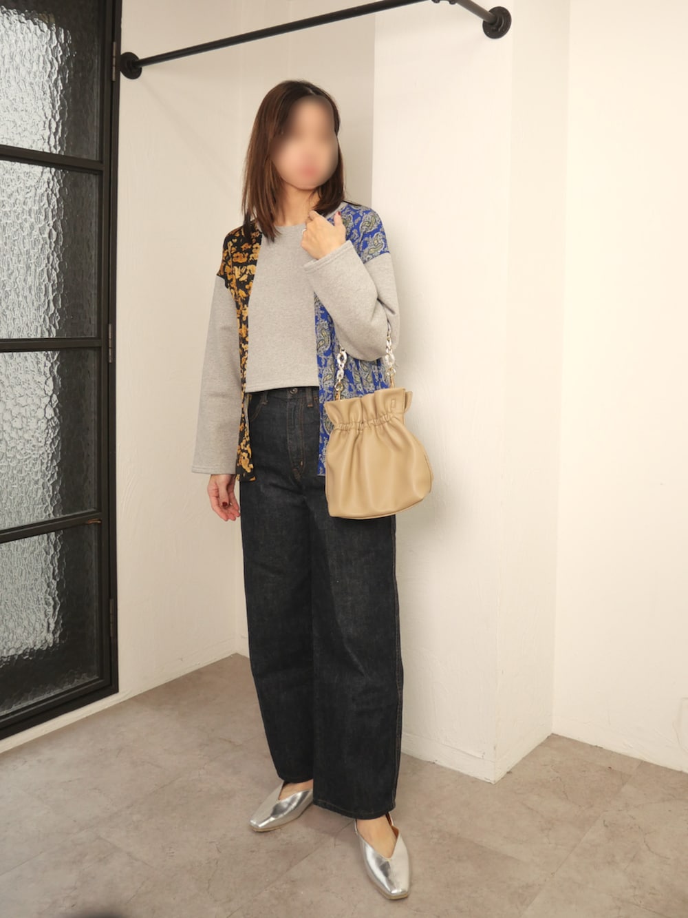 グレー系のスウェット、ベージュ系のハンドバッグを着用したレディースの冬コーディネートの2枚目の写真