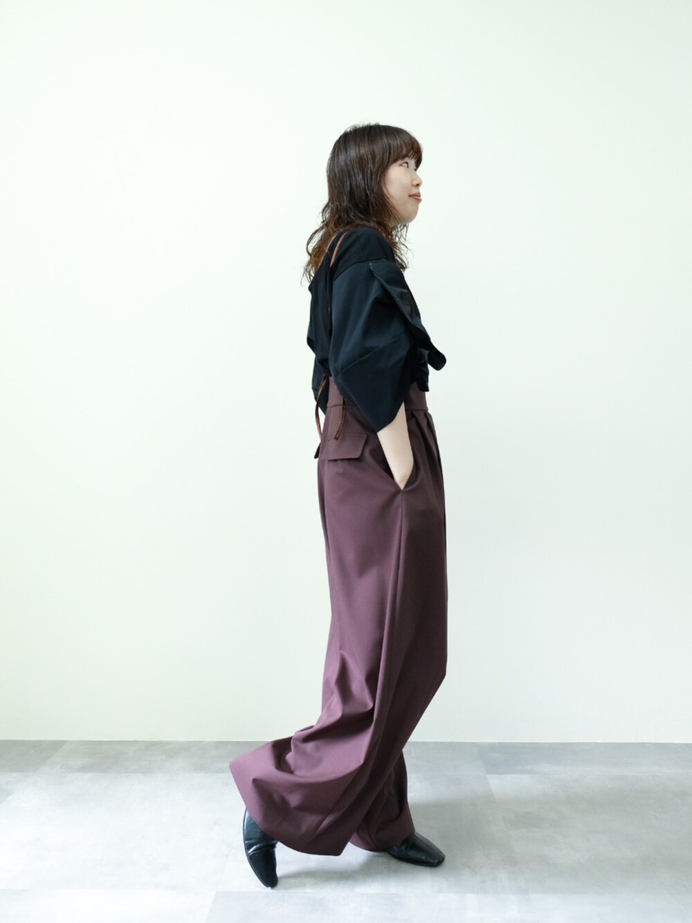 ブラック系のTシャツ/カットソー、ブラウン系のスラックスを着用したレディースの秋コーディネートの2枚目の写真