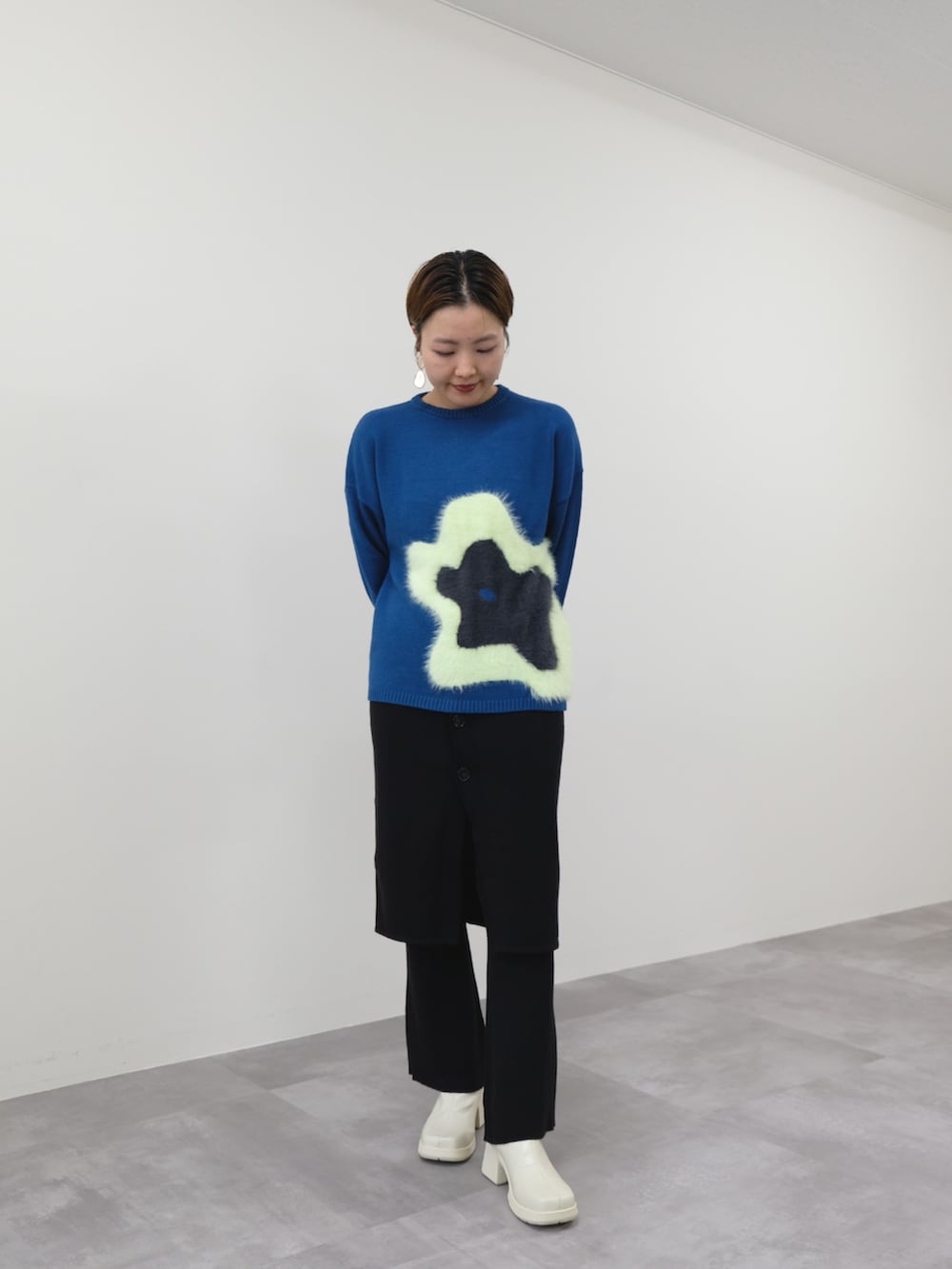 グリーン系のニット/セーター、ブラック系のその他パンツを着用したレディースの秋コーディネートの2枚目の写真