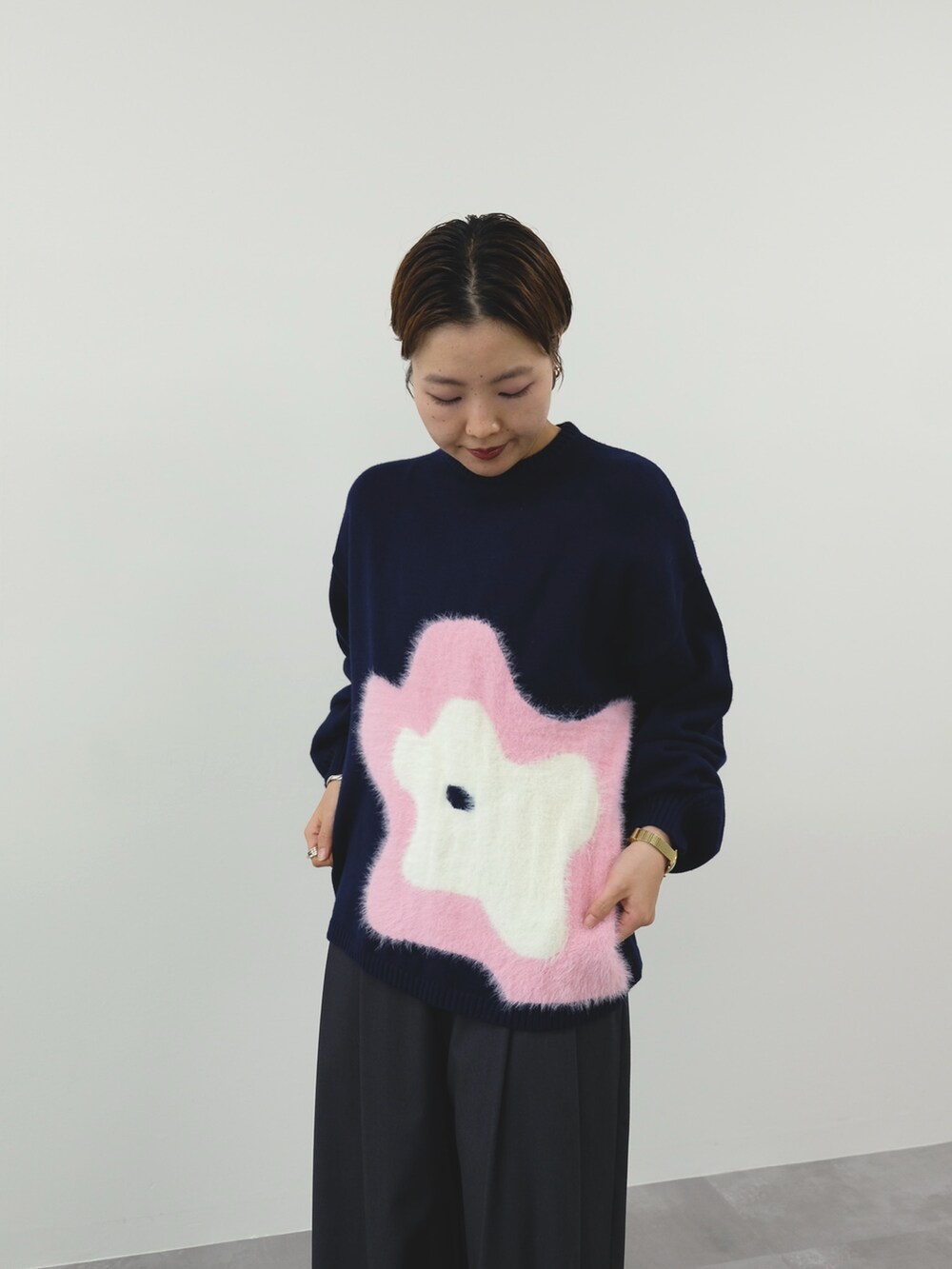 ブルー系のニット/セーター、グレー系のスラックスを着用したレディースの冬コーディネートの3枚目の写真