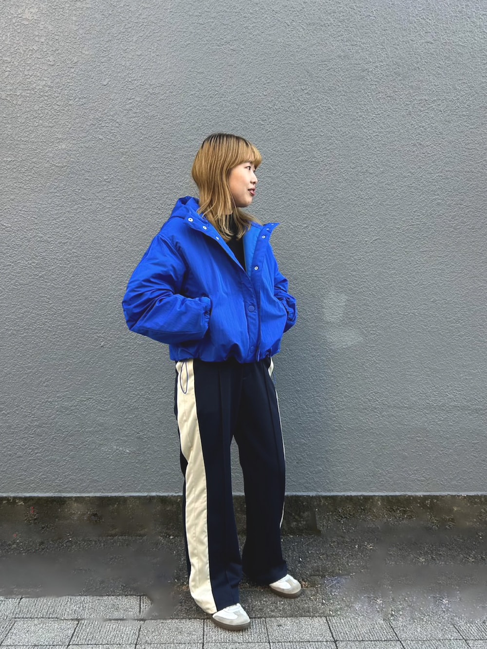 ブルー系のナイロンジャケット、ブラック系のニット/セーター、ブルー系のその他パンツを着用したレディースの秋コーディネートの2枚目の写真