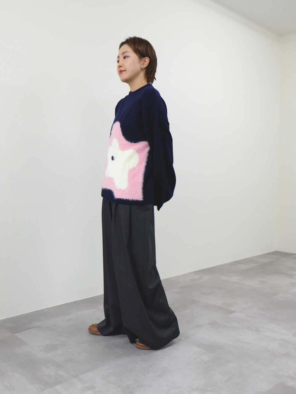 ブルー系のニット/セーター、グレー系のスラックスを着用したレディースの冬コーディネートの2枚目の写真