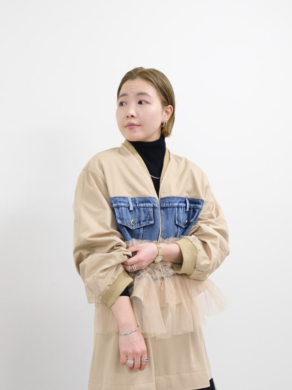 ベージュ系のスカート、ベージュ系のMA-1、ブラック系のニット/セーターを着用したレディースの冬コーディネートの4枚目の写真