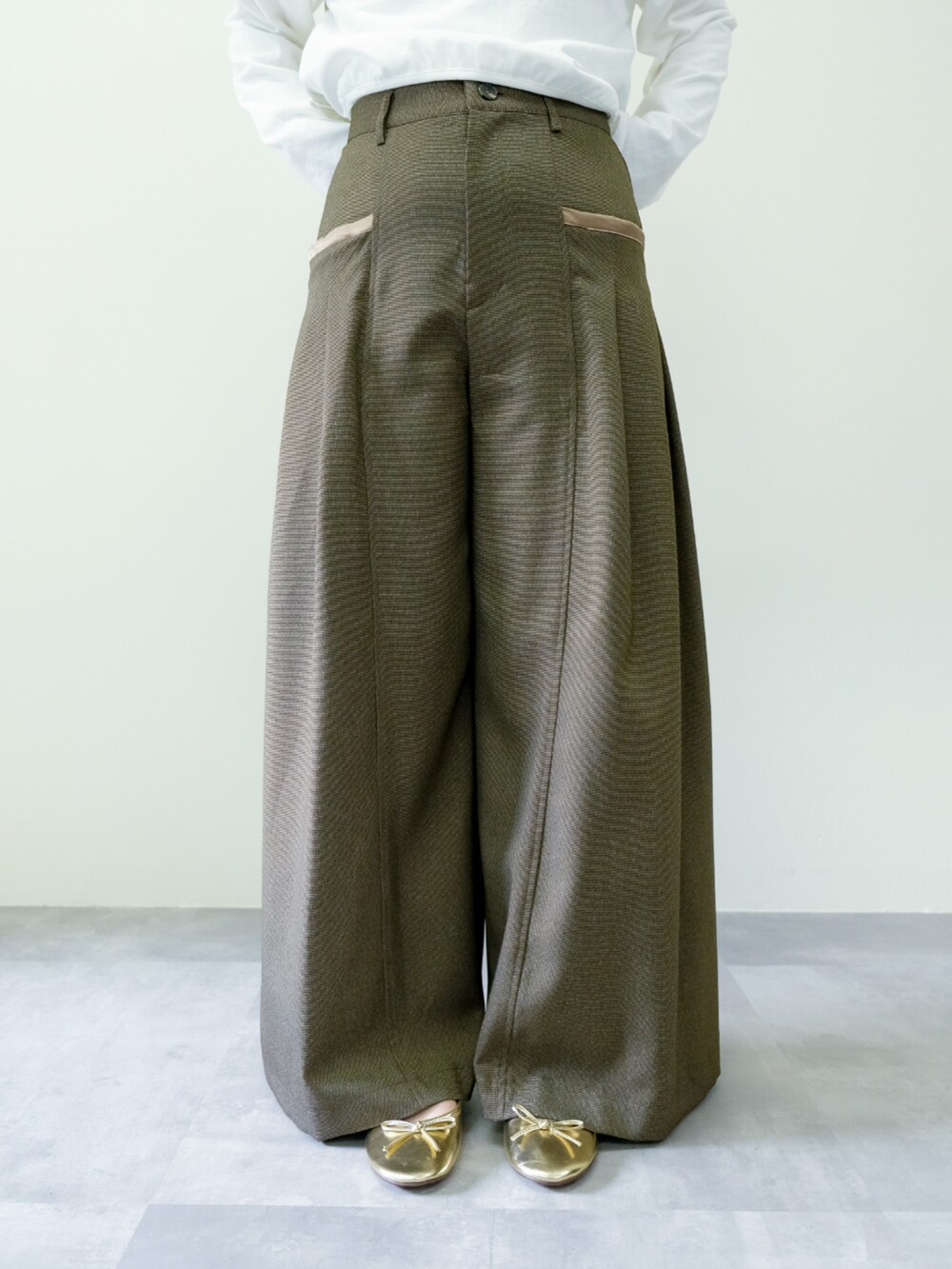 ホワイト系のTシャツ/カットソー、ブラウン系のスラックスを着用したレディースの秋コーディネートの4枚目の写真